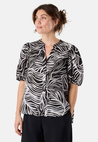 Black and white patterned blouse with short puff sleeves, a button-down front, and a mandarin collar. Lightweight, smooth fabric.