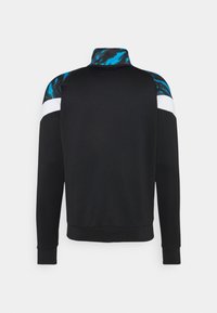 Schwarzer Pullover mit hohem Kragen, der blaue und schwarze Musterakzente an den Schultern sowie einen weißen Streifen aufweist. Weiche Stoffoberfläche.