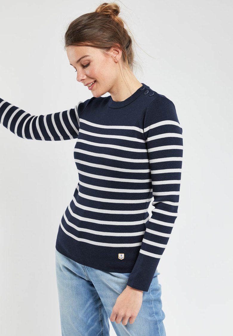 Maglione a righe blu navy e grigio, con scollo rotondo, maniche lunghe e dettagli con bottoni sulla spalla. Presenta una toppa con logo.