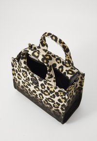 Sac à main en imprimé léopard avec deux poignées supérieures, compartiments zippés, et un extérieur en toile texturée dans des teintes de beige et de noir.