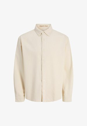 Chemise boutonnée beige clair en tissu doux, avec col classique, manches longues et six boutons à l'avant.