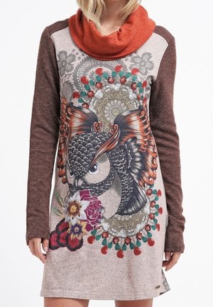 Langärmliges Kleid mit einem Cowl-Neck, braunen Ärmeln, einem hellbraunen Körper und einem großen Eulenmotiv mit floralen Akzenten und bunten Details.