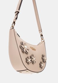 Borsa a mano beige realizzata in materiale sintetico, con decorazioni floreali sovrapposte e dettagli in perle, dotata di logo e accessori in tonalità oro. Tracolla regolabile.