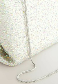 Clutch bag in white fabric with an array of small, iridescent and clear gems. Features a silver chain strap. Textured surface with sparkling accents.