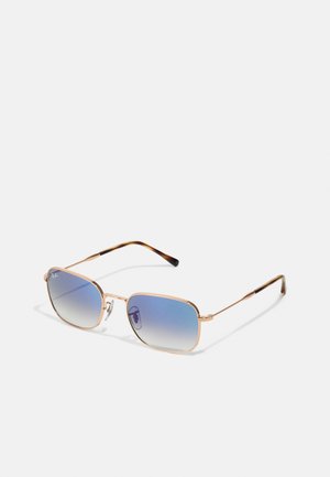 Occhiali da sole in metallo dorato con forma quadrata, lenti blu sfumate e dettagli in tartaruga sulle tempie.