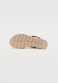 Beige sandal outsole with a textured grip pattern and light-colored sole. Features brand name "Gabor" embossed near the heel.