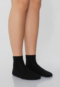 Czarne skarpetki do kostki wykonane z miękkiego, elastycznego materiału, z prążkowanym ściągaczem i gładką fakturą, zaprojektowane z myślą o wygodnym dopasowaniu do stopy.