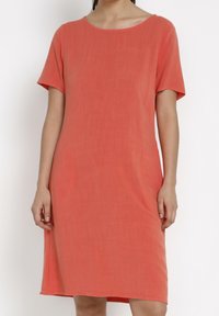 Kortärmad korallklänning i mjukt tyg med avslappnad passform, rund halsringning och knälång längd. Minimalistisk design.
