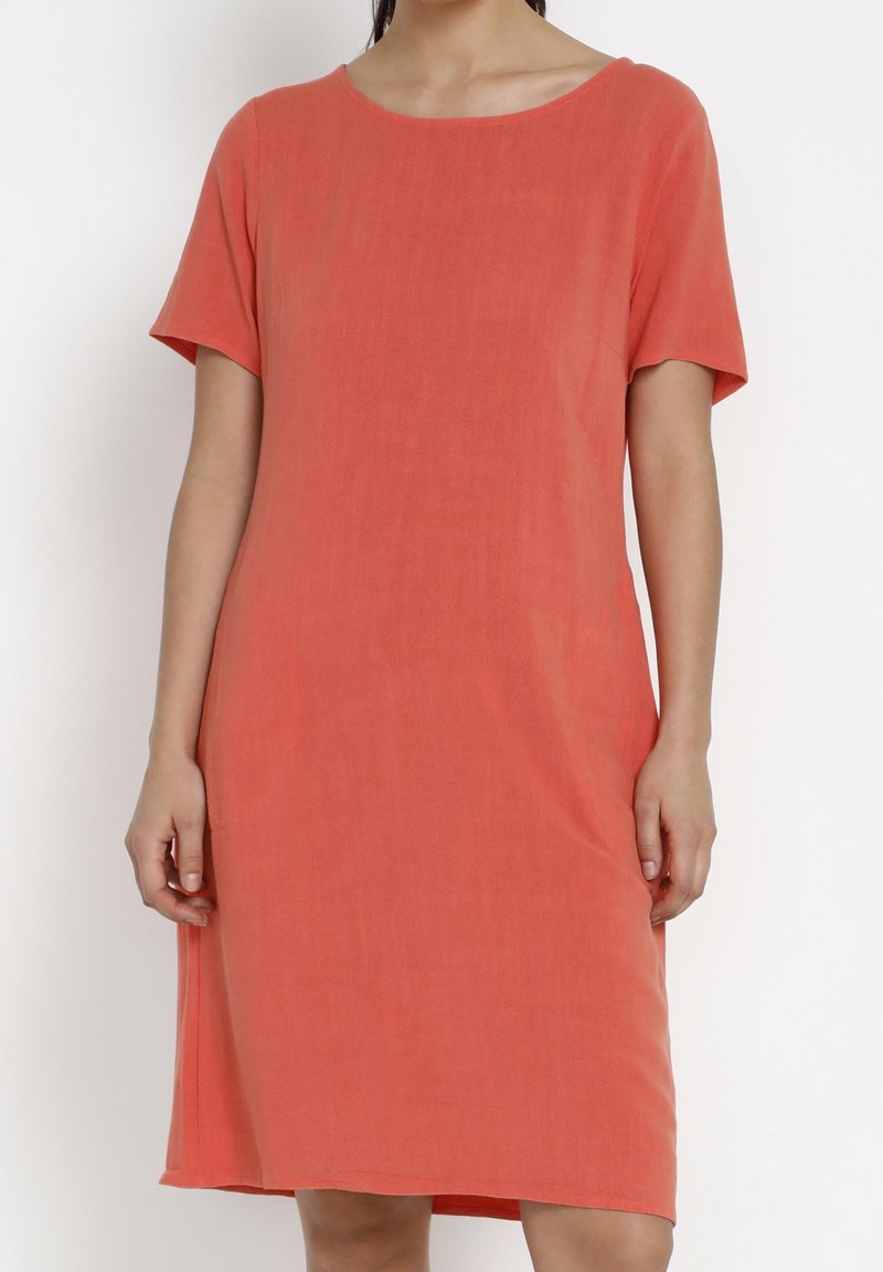 Kortärmad korallklänning i mjukt tyg med avslappnad passform, rund halsringning och knälång längd. Minimalistisk design.