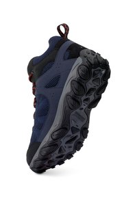 Chaussure de randonnée bleu foncé et noire, présentée en angle pour montrer la semelle épaisse, texturée, gris et noire, avec une languette et des lacets accentués de rouge.