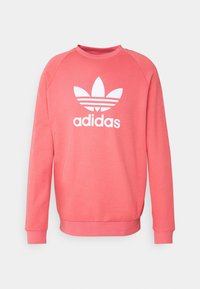 Korallenrosa Adidas Sweatshirt mit langen Ärmeln, Rundhalsausschnitt und weißem Trefoil-Logo in der Mitte der Brust.