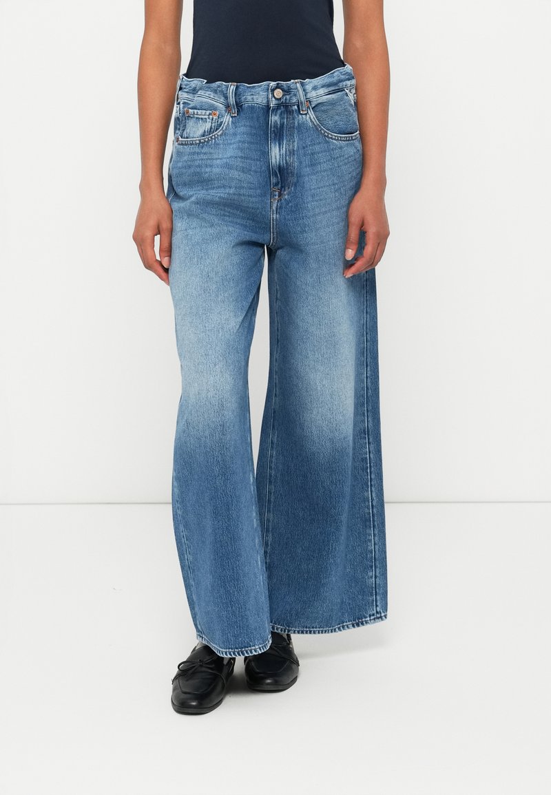 Φαρδιά μπλε τζιν παντελόνια με απαλό φινίρισμα, σχεδίαση πέντε τσέπες και ψηλή μέση. Διαθέτουν επώνυμα κουμπιά και αντίθεση στη ραφή.