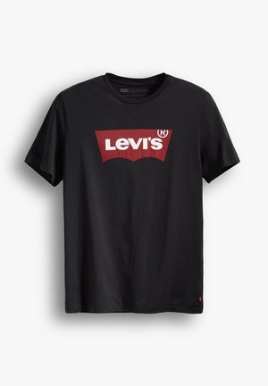Camiseta negra de algodón con cuello redondo. Presenta un gran logo rojo de Levi's sobre un fondo blanco y una pequeña etiqueta roja en el lado inferior.
