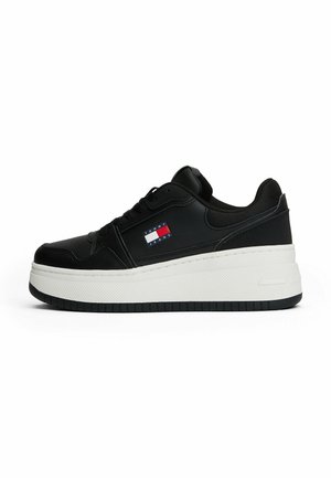 Sneaker nera con tomaia in pelle liscia, suola platform bianca e dettaglio del logo in rosso, bianco e blu sul lato.