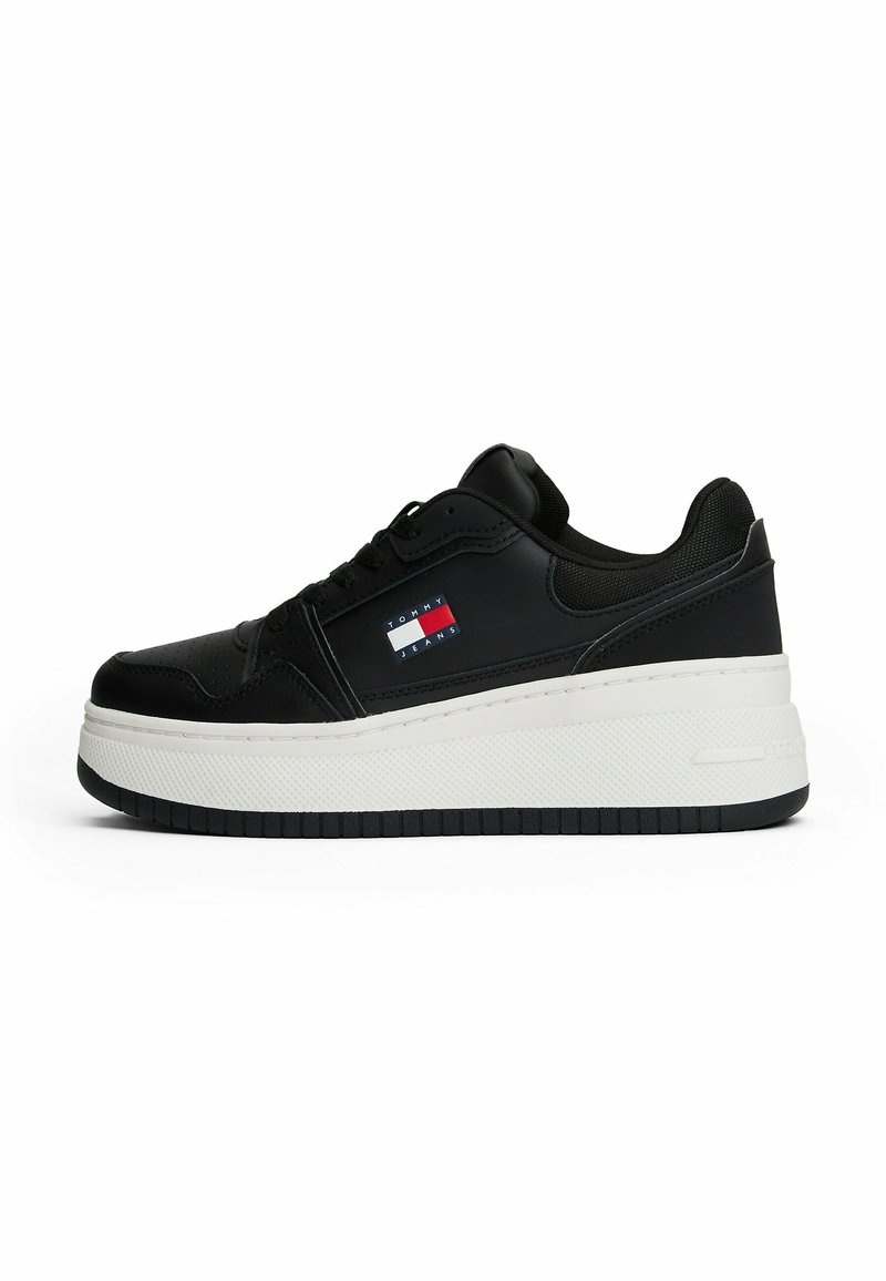 Sneaker nera con tomaia in pelle liscia, suola platform bianca e dettaglio del logo in rosso, bianco e blu sul lato.