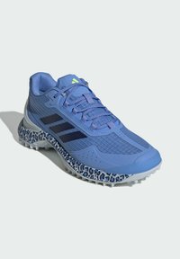 Blue athletic shoe with textured upper, three black stripes, and a leopard print midsole. Features a cushioned sole and lacing system.
