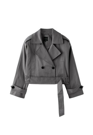 Trench-coat gris raccourci avec larges revers, boutons noirs croisés, taille ceinturée et poignets boutonnés, posé à plat sur fond blanc.