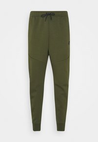Olivgrön joggerbyxor tillverkade av mjukt tyg, med en avsmalnande passform, elastisk midja med dragsnodd och sidfickor.