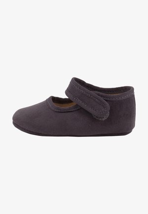 Zapato de tela gris oscuro con puntera redonda y correa de velcro, que presenta una textura suave y una suela plana y flexible.