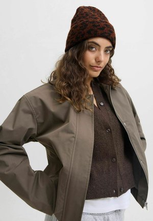 Bruine wollen muts met een dierenpatroon, grijze ritsjack en donkerbruine cardigan. De jas heeft een gladde textuur en een relaxte pasvorm.