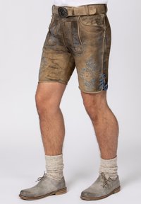 Leather shorts in brown with blue floral embroidery. Features a belt and decorative lacing on the sides. Worn with gray boots and socks.