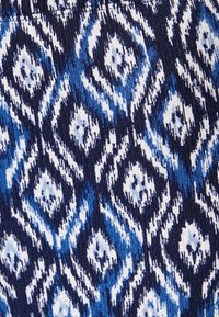 Blauw en wit patroonstof met een diamantdesign, met een textuurafwerking. De achtergrond is overwegend donkerblauw.