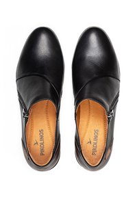 Scarpe in pelle nera con punta arrotondata, zip laterale e soletta tan. Presentano una texture liscia e sottili dettagli in cucitura. Marca: Pikolinos.