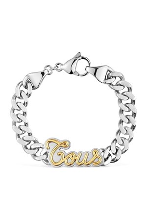Bracelet chaîne en argent avec une plaque logo "Tous" en or et argent et une fermeture à mousqueton sur fond blanc.