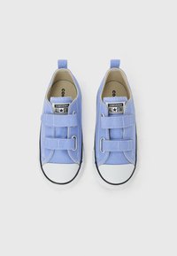 Ανοιχτό μπλε παιδικά αθλητικά παπούτσια Converse All Star με λευκές λαστιχένιες μύτες και διπλά Velcro λουριά σε λευκό φόντο.