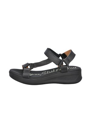 Sandalia negra con correas de cuero texturizado, herrajes ajustables y plataforma baja. Cuenta con una plantilla acolchada y puntera redondeada.