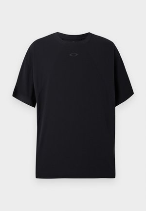 T-shirt noir à manches courtes en tissu léger, avec un col rond, des manches raglan et un logo discret sur la poitrine.