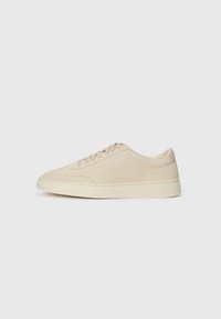 Beige suede low-top sneaker with laces, round toe, and a thick rubber sole, shown in right side profile on a white background.