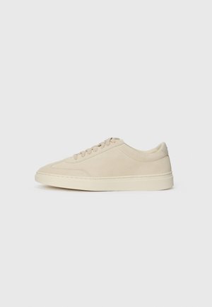 Beige suede low-top sneaker with laces, round toe, and a thick rubber sole, shown in right side profile on a white background.