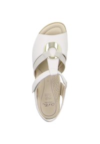 Witte sandaal met een open neus ontwerp, voorzien van een ronde metalen accent, gekruiste banden en een gevoerde inlegzool. Textuur bovenmateriaal.