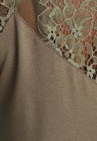 Olive green lace detail on a smooth, taupe fabric, showcasing a floral pattern with a slight sheen and a soft texture.