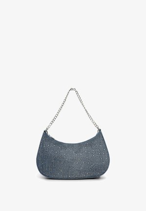 Dżinsowa torba na ramię z srebrnym łańcuszkiem, ozdobiona małymi metalowymi ćwiekami dla tekstury. Zaokrąglony kształt i różne odcienie niebieskiego.