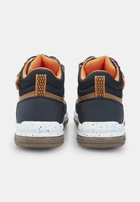 Zapatillas altas con una parte superior de malla azul marino y forro naranja, detalles en marrón y una suela moteada blanca y marrón. Tira de velcro en el lateral.