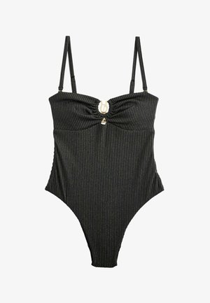 Juoda vientisa maudymosi kostiumėlis su plonomis vertikaliomis sidabrinėmis juostelėmis, reguliuojamomis petnešėlėmis ir apskritu metaliniu užsegimu krūtinės centre.