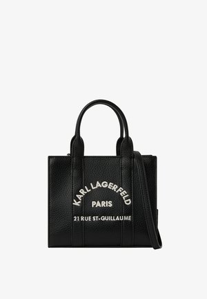 Czarna skórzana torebka z dwoma uchwytami i długim paskiem, z białym tekstem "Karl Lagerfeld Paris 21 Rue St-Guillaume" z przodu.