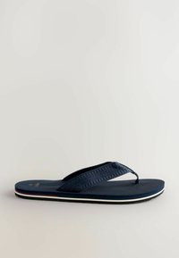 Navy blue flip-flop with textured rubber strap and footbed, white horizontal stripe on the sole, minimalist design, no visible branding.