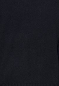 Pull bleu marine foncé en matière douce tricotée. Caractérisé par une texture lisse et un design simple avec un ourlet et des poignets côtelés.