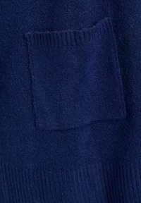 Pull en maille bleu marine avec une finition texturée, doté d'une poche frontale carrée et d'un ourlet côtelé en bas.