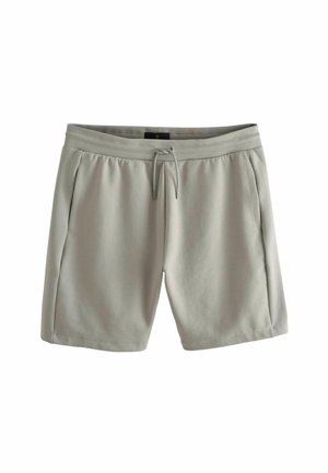 Pantaloni sportivi grigio chiaro realizzati in tessuto morbido, dotati di vita elastica, chiusura con lacci e tasche laterali.