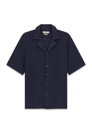 Chemise bleu marine à manches courtes avec col pointu et cinq boutons sur le devant, étalée à plat sur un fond blanc.