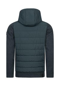Hooded jaka ar tumši zaļu piešūtu audumu augšējā daļā un faktūru pelēkajām piedurknēm. Iespējas ietver adītu apakšmali un smalkus šuvju detalizējumus.