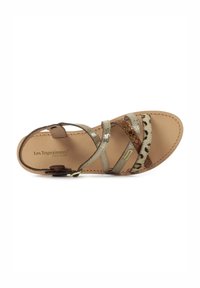 Sandalia plana con múltiples correas en tonos beige, marrón y texturas metálicas. Presenta estampado animal, una suela acolchada y una correa ajustable en el tobillo.
