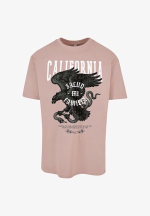 Lühikeste varrukatega, helesinine puuvillane T-särk, millel on suur must kotka graafika, ja tekst "CALIFORNIA" ning "SALUD MI FAMILIA" suurtes valgetes tähtedes.