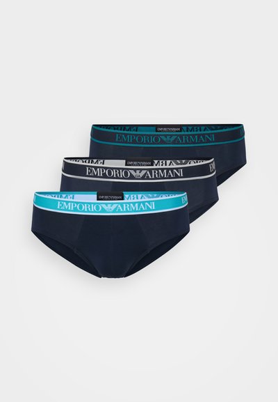 Tre paia di slip da uomo blu navy con cinturini elastici che presentano il logo "Emporio Armani" in grigio e accenti turchesi.