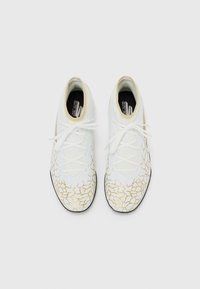 Witte sportieve schoenen met een gebroken gouden ontwerp, textuurmateriaal, ronde neus en platte veters. Rubberen zool voor grip.
