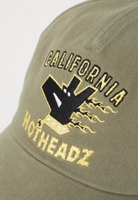 Olivengrøn cap med en buet skygge udstyret med sort og gul broderet tekst "CALIFORNIA HOTHEADZ" og et grafisk design i midten.